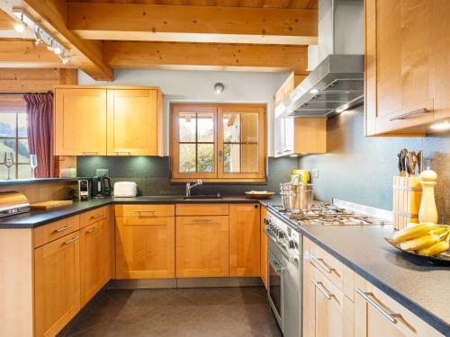 a kitchen with wooden cabinets and a stove top oven at Chalet Godfrey by Interhome in Les Crosets