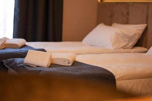 two beds in a hotel room with towels on them at Nest Suites in Skopje