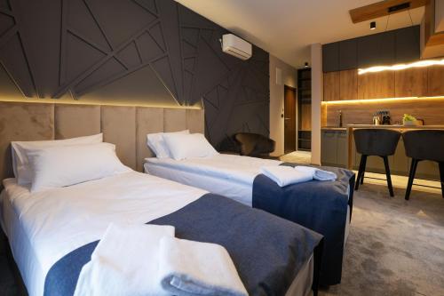 a hotel room with two beds and a kitchen at Nest Suites in Skopje