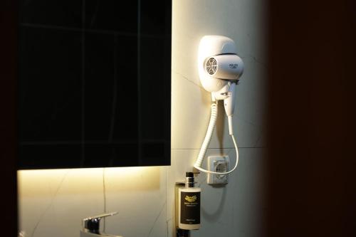 a blow dryer on the wall of a bathroom at Nest Suites in Skopje