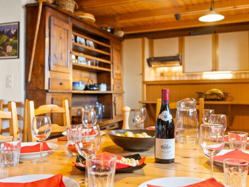 a wooden table with glasses and a bottle of wine at Chalet Chalet Seravalle by Interhome in Les Crosets