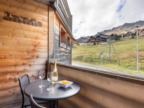 a table with a bottle of wine and two glasses at Apartment Sundance 10-1 by Interhome in Les Crosets