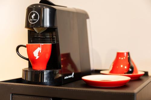 a coffee maker on a counter with a red cup at Kamengrad Hotel & SPA in Panagyurishte