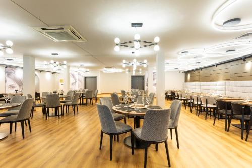 a restaurant with tables and chairs in a room at Kamengrad Hotel & SPA in Panagyurishte