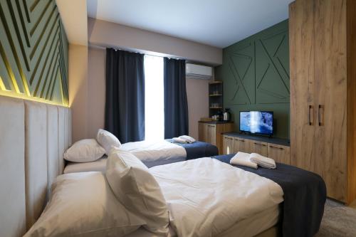 a hotel room with two beds and a television at Nest Suites in Skopje