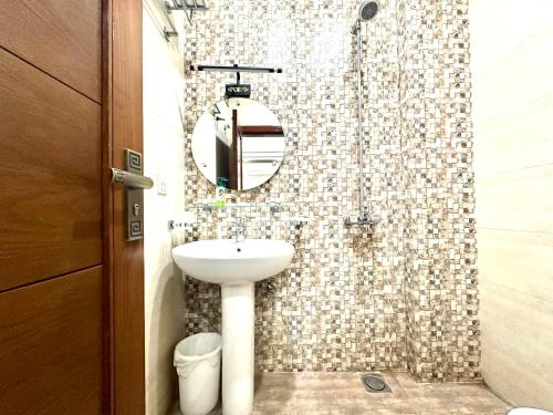 a bathroom with a sink and a shower with a mirror at Mukhtar Homes Bahria Town Lahore in Lahore