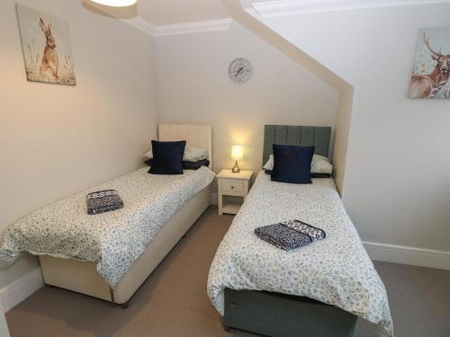 two twin beds in a room with at Rookley Lake Cottage in Ventnor