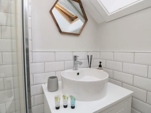 a white bathroom with a sink and a mirror at Rookley Lake Cottage in Ventnor