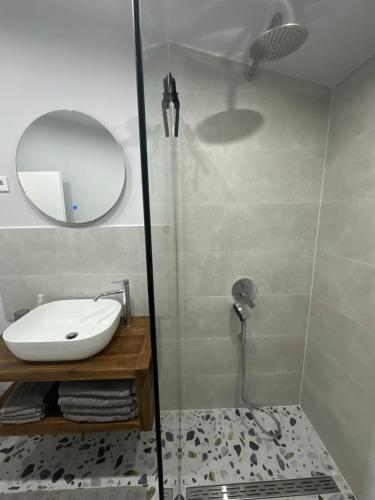 a bathroom with a shower with a sink and a mirror at Villa Lulu in Orebić