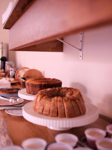 Een hoop taarten op borden op tafel. bij POUSADA NOSSO LAR in Guarujá
