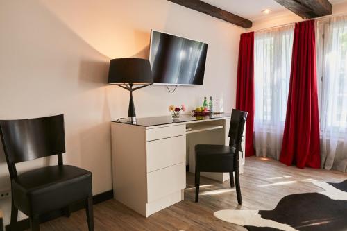 a room with a desk and chairs and red curtains at Hotel im Haus zur Hanse in Braunschweig