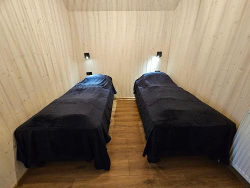 two beds in a small room with at Úthlíd Cottages in Úthlid
