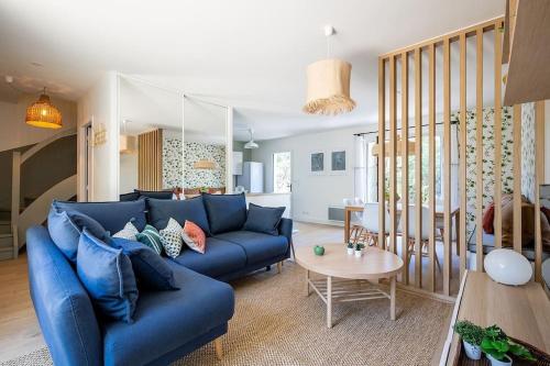 un salon avec un canapé bleu et une table dans l'établissement Villa Fougères à deux pas de la plage PYLA SUR MER, à La Teste-de-Buch