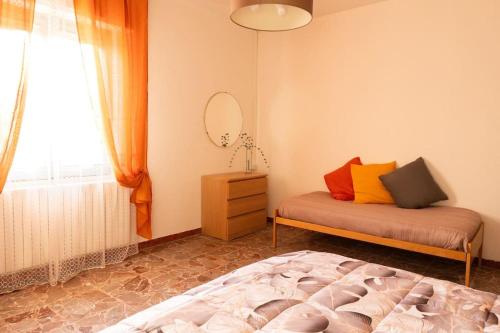 a bedroom with a bed and a mirror and a window at Da zia Concetta, casa vacanze immersa nel verde in Colledara