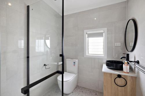 a bathroom with a toilet and a glass shower at Avenue Delight in Rosebud