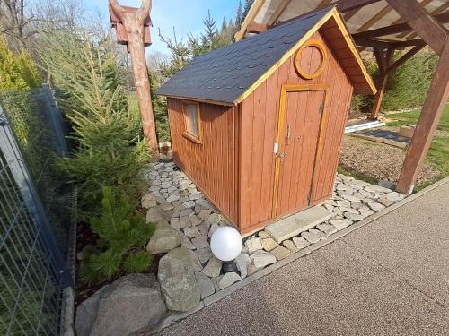 a small woodenshed with a white ball in a stone yard at Drewniany Domek Daria i Tomek 2 domki na 8 osób in Stronie Śląskie