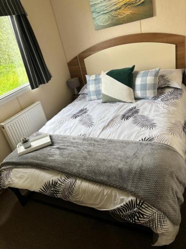 ein Schlafzimmer mit einem Bett, auf dem ein Buch liegt in der Unterkunft Tattershall Lakes Pet Friendly Hot Tub Breaks in Tattershall