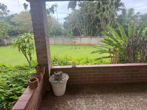 a patio with a brick wall and some plants at Warners Guesthouse in Kingsburgh
