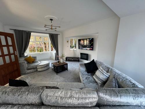 a living room with a couch and a table at Manchester City Oasis - Spacious 5 Bedroom House in Manchester