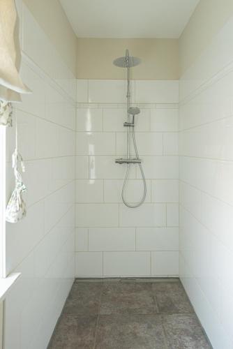 a white tiled shower with a shower head at Storchenhof Blumenow in Blumenow