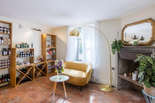 a living room with a chair and a mirror at Demeures et Châteaux Moulin des Templiers Hôtel & SPA in Pontaubert