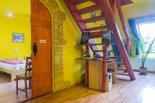 Habitación con escalera de madera y paredes amarillas. en 7x24 Central Hostel en Budapest