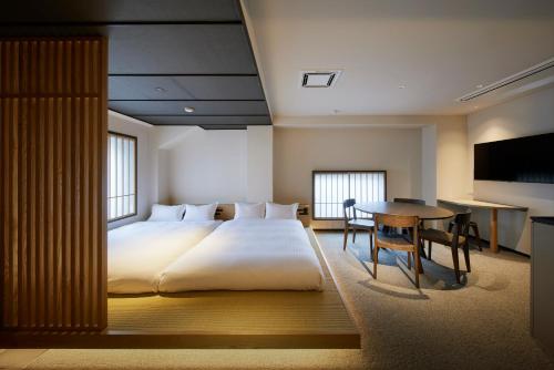 a bedroom with a large bed and a table at Minn Asakusa Kuramae North in Tokyo