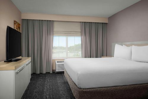 a hotel room with a bed and a television at Hilton Garden Inn Fredericksburg in Fredericksburg
