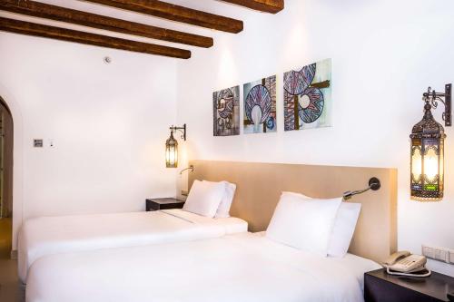 two beds in a room with white walls at Hilton Marsa Alam Nubian Resort in Abu Dabab