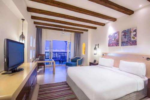 a hotel room with a bed and a television at Hilton Marsa Alam Nubian Resort in Abu Dabab