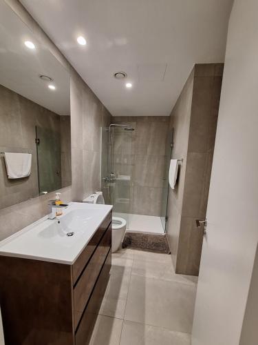 a bathroom with a sink and a toilet and a shower at Emerald Suites in Protaras