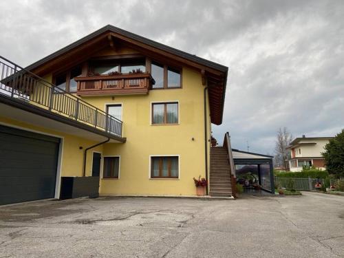 a yellow house with a balcony on top of it at B&B casa Orsingher a 2 passi da Belluno in Trichiana