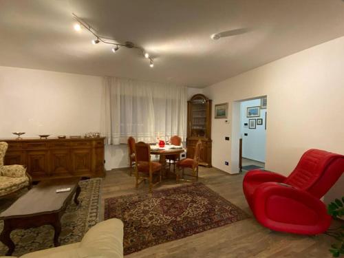 a living room with a red couch and a table at B&B casa Orsingher a 2 passi da Belluno in Trichiana