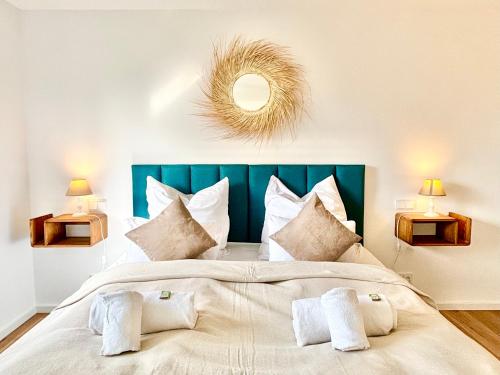 a bedroom with a large bed with a blue headboard at Snug Stays 5 - Design Apartment mit Sonnenbalkon, ruhig, zentral in Herrsching am Ammersee