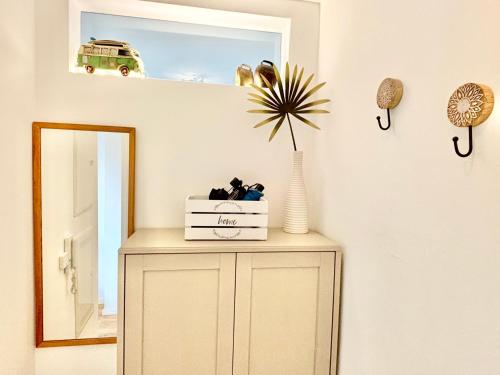 a dresser in a room with a mirror at Snug Stays 5 - Design Apartment mit Sonnenbalkon, ruhig, zentral in Herrsching am Ammersee