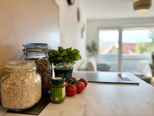 a counter with jars of food and tomatoes on it at Snug Stays 5 - Design Apartment mit Sonnenbalkon, ruhig, zentral in Herrsching am Ammersee