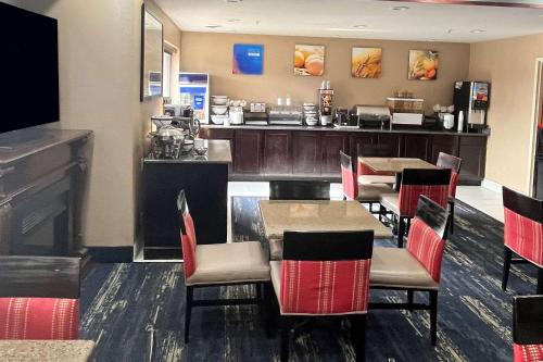 a restaurant with tables and chairs and a bar at Comfort Inn & Suites in Jackson
