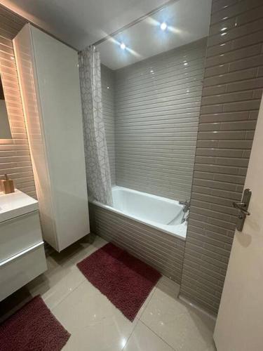 une salle de bain avec une baignoire et un lavabo dans l'établissement Paris La Défense, à Puteaux