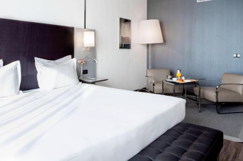 a large white bed in a hotel room at AC Hotel by Marriott Madrid Airport in Coslada