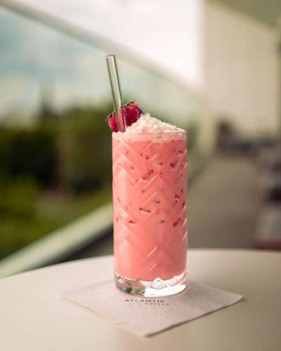 a pink drink with a raspberry on a napkin at ATLANTIC Hotel Münster in Münster