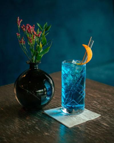 a vase with a drink and a vase with flowers at ATLANTIC Hotel Münster in Münster