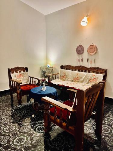a living room with two chairs and a table at Coco inn Goa in Candolim