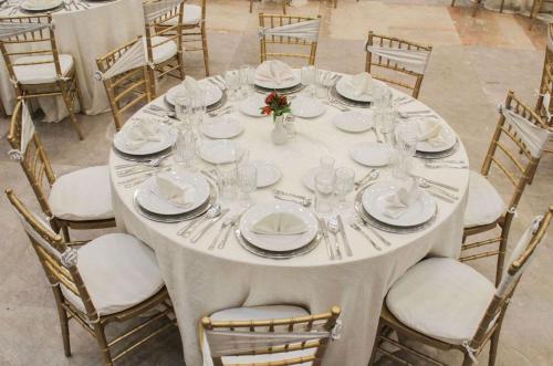 a table with white plates and glasses on it at Radisson Hotel & Convention Center Toluca in Toluca