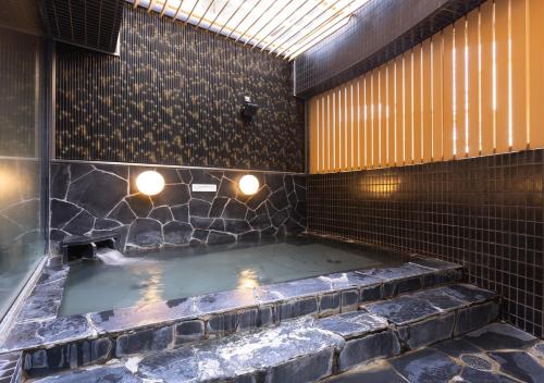 a hot tub in a tiled room with at APA Hotel Sendai Eki Itsutsubashi in Sendai