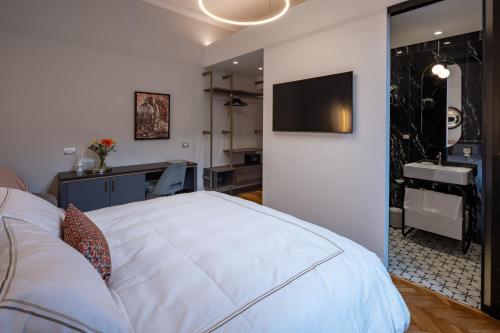 a bedroom with a white bed and a bathroom at Migliori Collection Suites Via Veneto in Rome