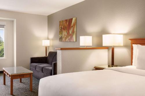 a hotel room with a bed and a couch at Radisson Hotel Portland Airport in Portland