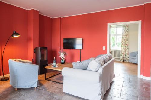 a living room with red walls and a white couch at Storchenhof Blumenow in Blumenow