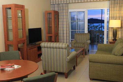 a living room with chairs and a table and a television at Radisson Hotel Panama Canal in Panama City