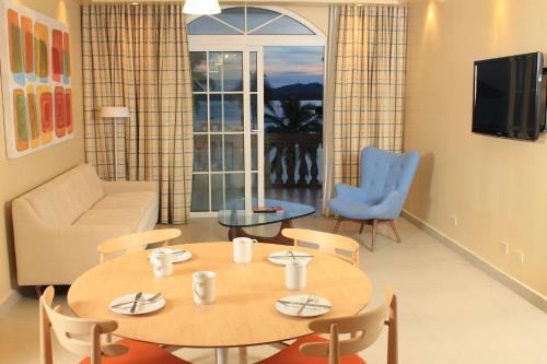 a living room with a table and chairs and a television at Radisson Hotel Panama Canal in Panama City