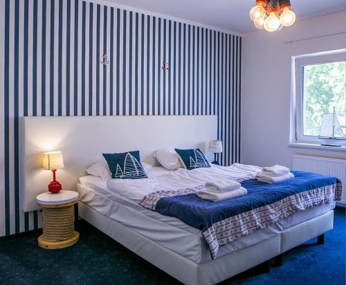 a bedroom with a large bed with towels on it at Marina Mikołajki in Mikołajki